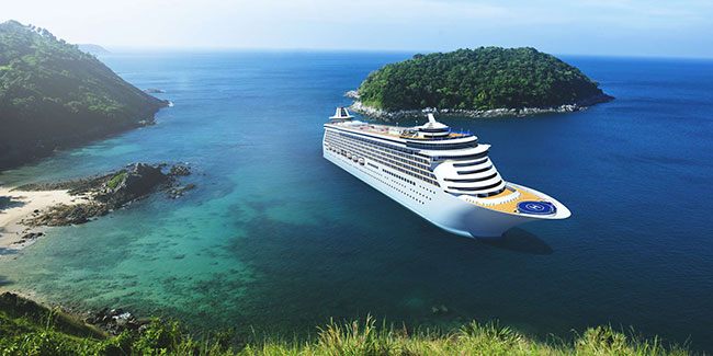 Cruise ship passing a small green island in the Caribbean