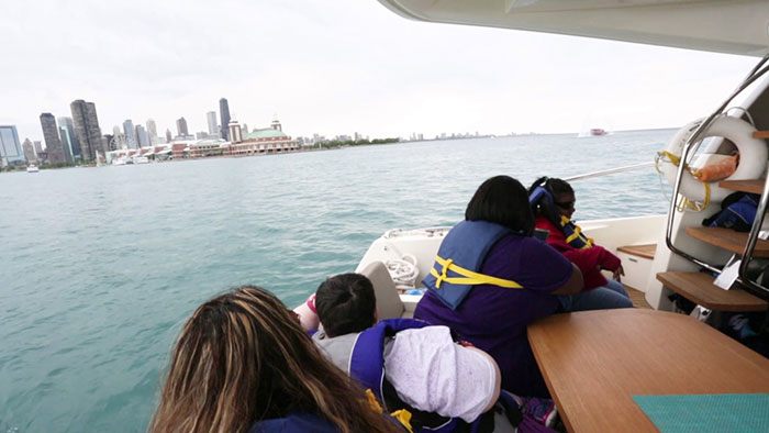 Guests at a ship window watching a city skyline