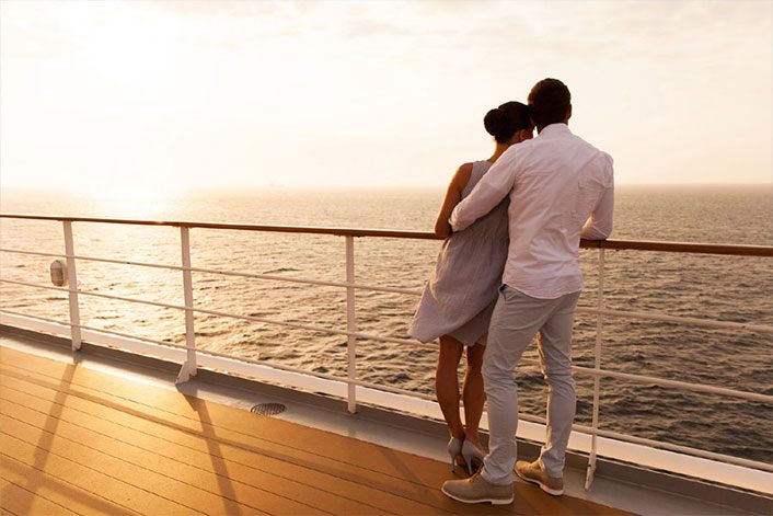 Couple at a ship rail watching the sunset