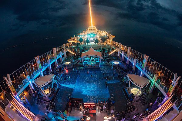 Lit-up pool deck at night during a party at sea