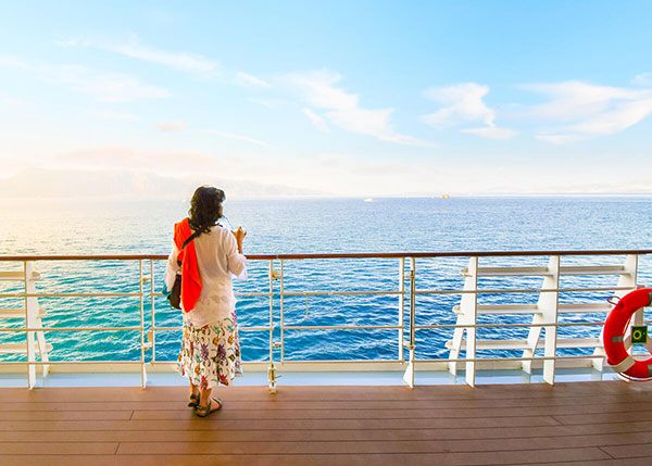 Traveler at a ship rail looking out to sea