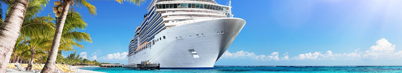 Bow of a large cruise ship docked under a blue sky