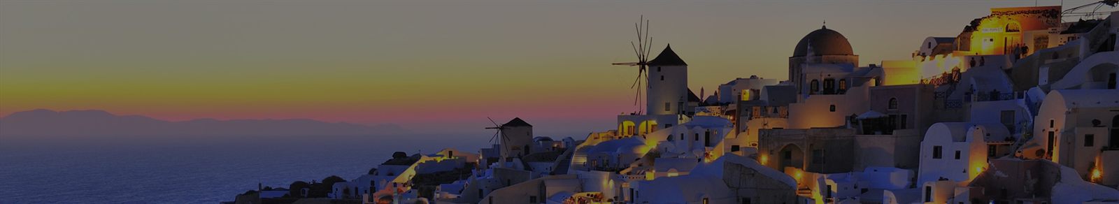Sunset over the windmills and white houses of Oia, Santorini